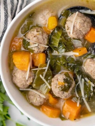 partial view of Italian wedding soup in white bowl