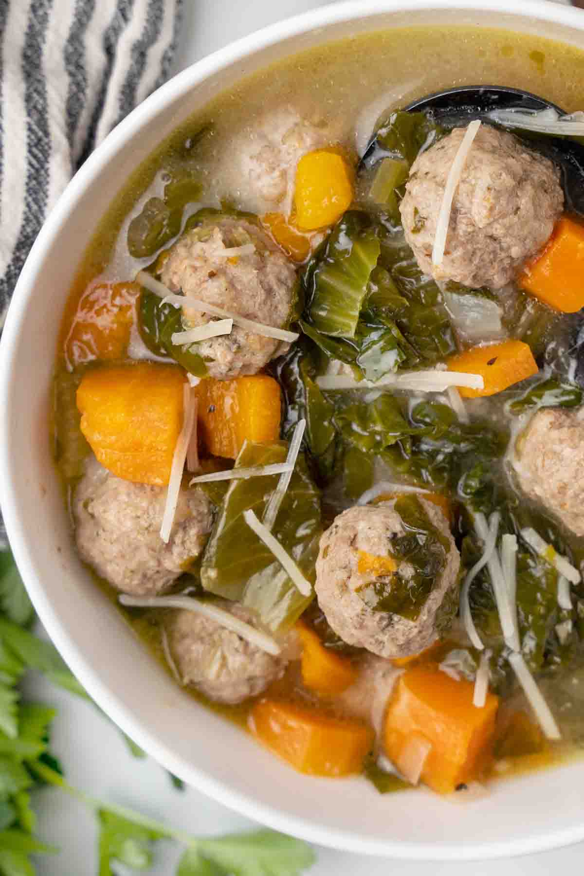 partial view of Italian wedding soup in white bowl