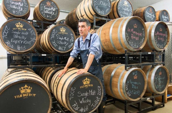 Sebastian Roy in front of Whiskey and other Spirit barrels at his distillery in