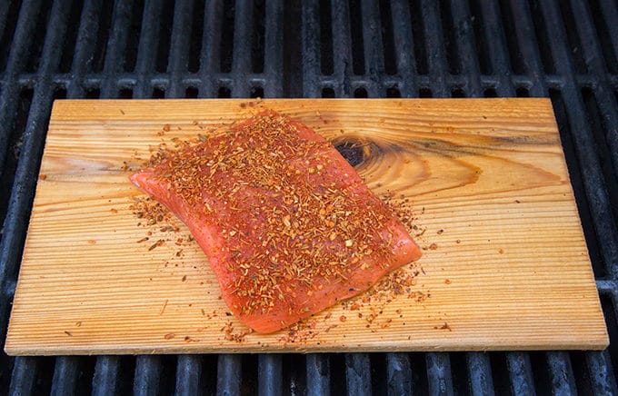 Uncooked Seasoned Salmon on Plank on grill grates