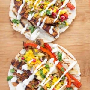 2 grilled chicken fajitas on a cutting board