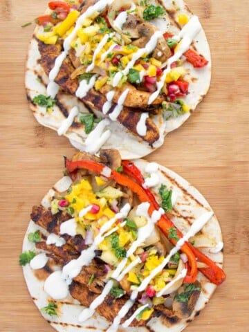 2 grilled chicken fajitas on a cutting board