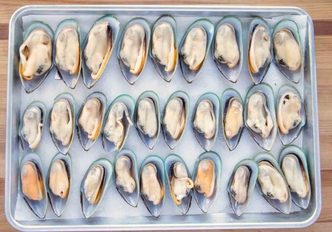 thirty mussels on the half shell on a half sheet pan