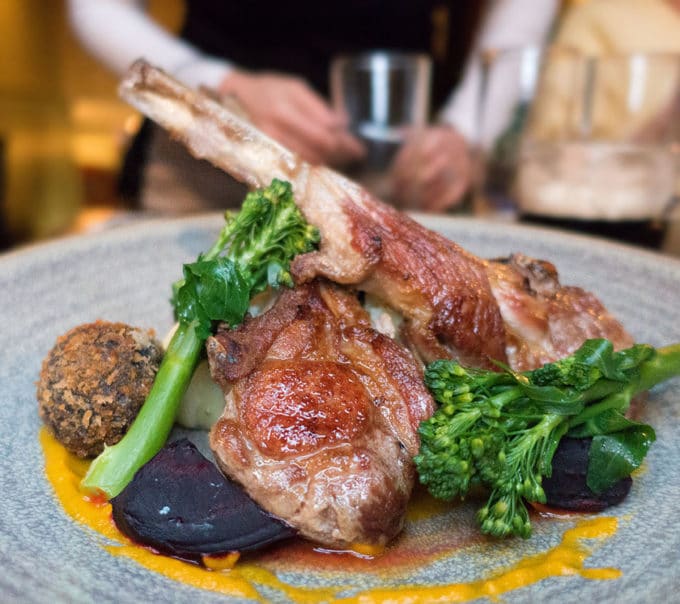 lamb chops crossed on a grey plate with broccolini at Mulligans Grocer in Dublin Ireland
