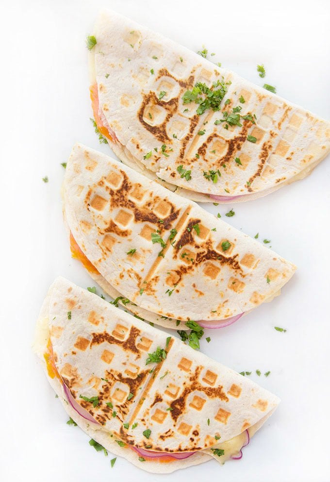 3 nicely browned smoked salmon quesadillas sitting on a white platter