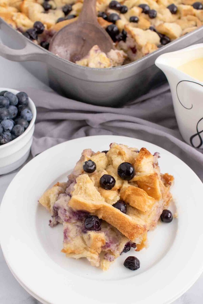 portion fo blueberry bread pudding on a white plate without the cream anglais