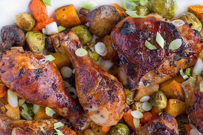 chai marinated chicken on a bed of roasted vegetables on a white platter