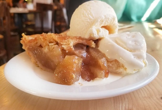 apple pie with ice cream sitting on a white plate at Whidbey Pies and Cafe 