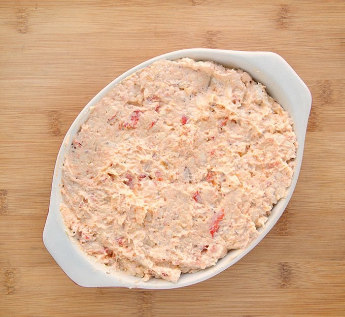 cheddar lobster dip in a baking dish on a cutting board