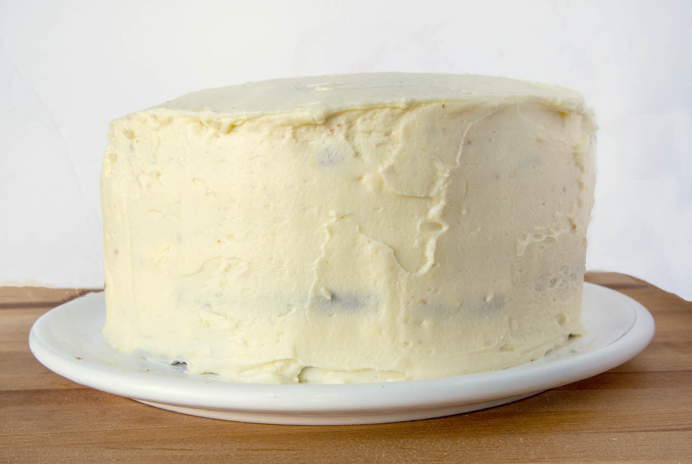 pumpkin crunch cake frosted on a white platter