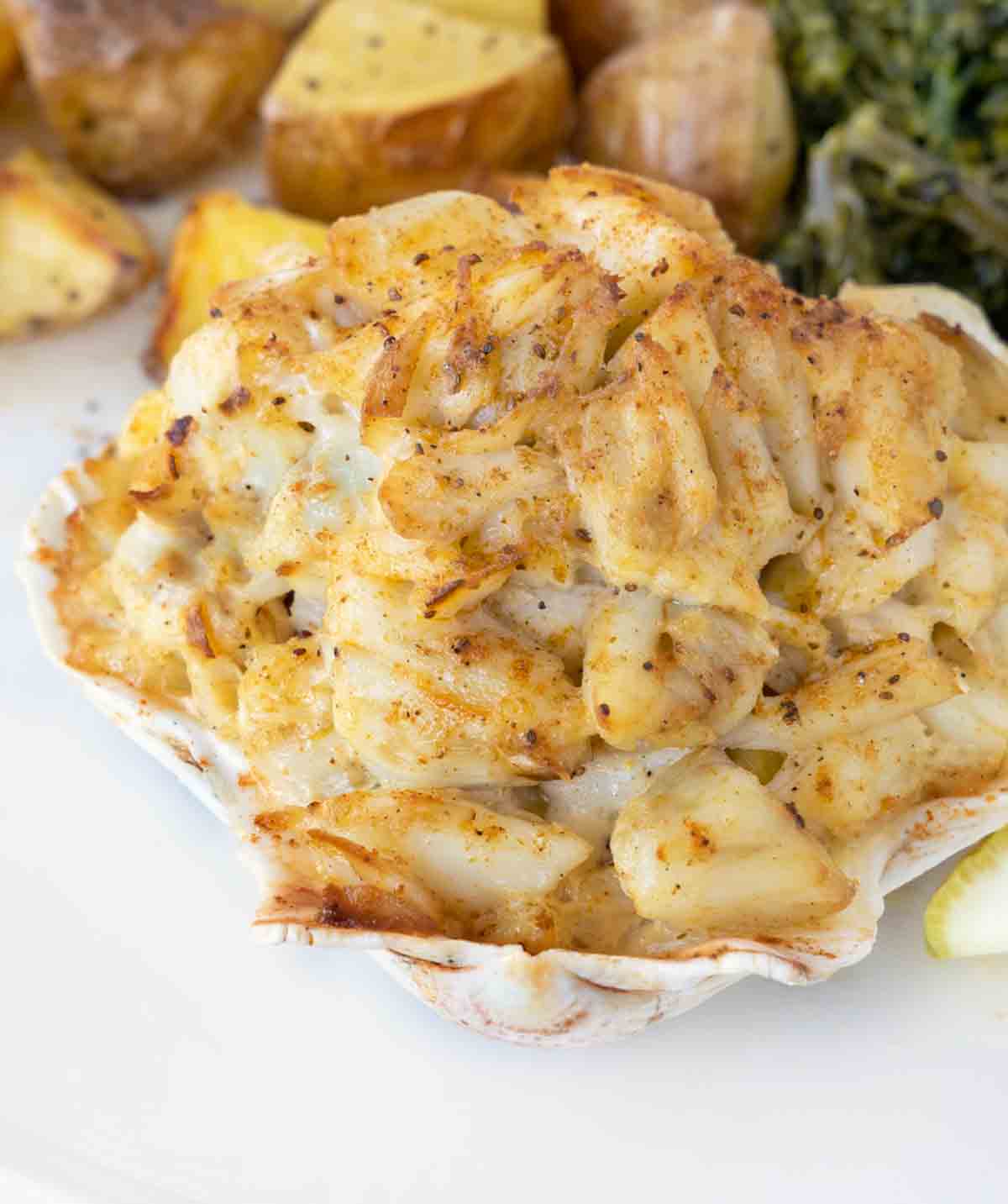 overhead close up of baked crab imperial in a shell on a white plate