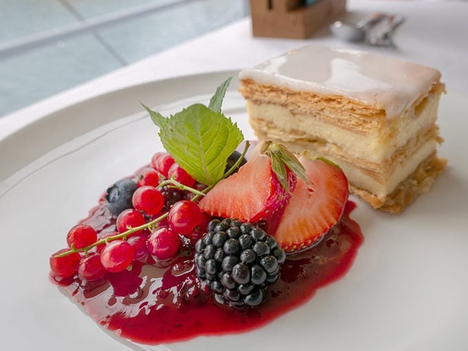 A piece of cake with berries on a white plate