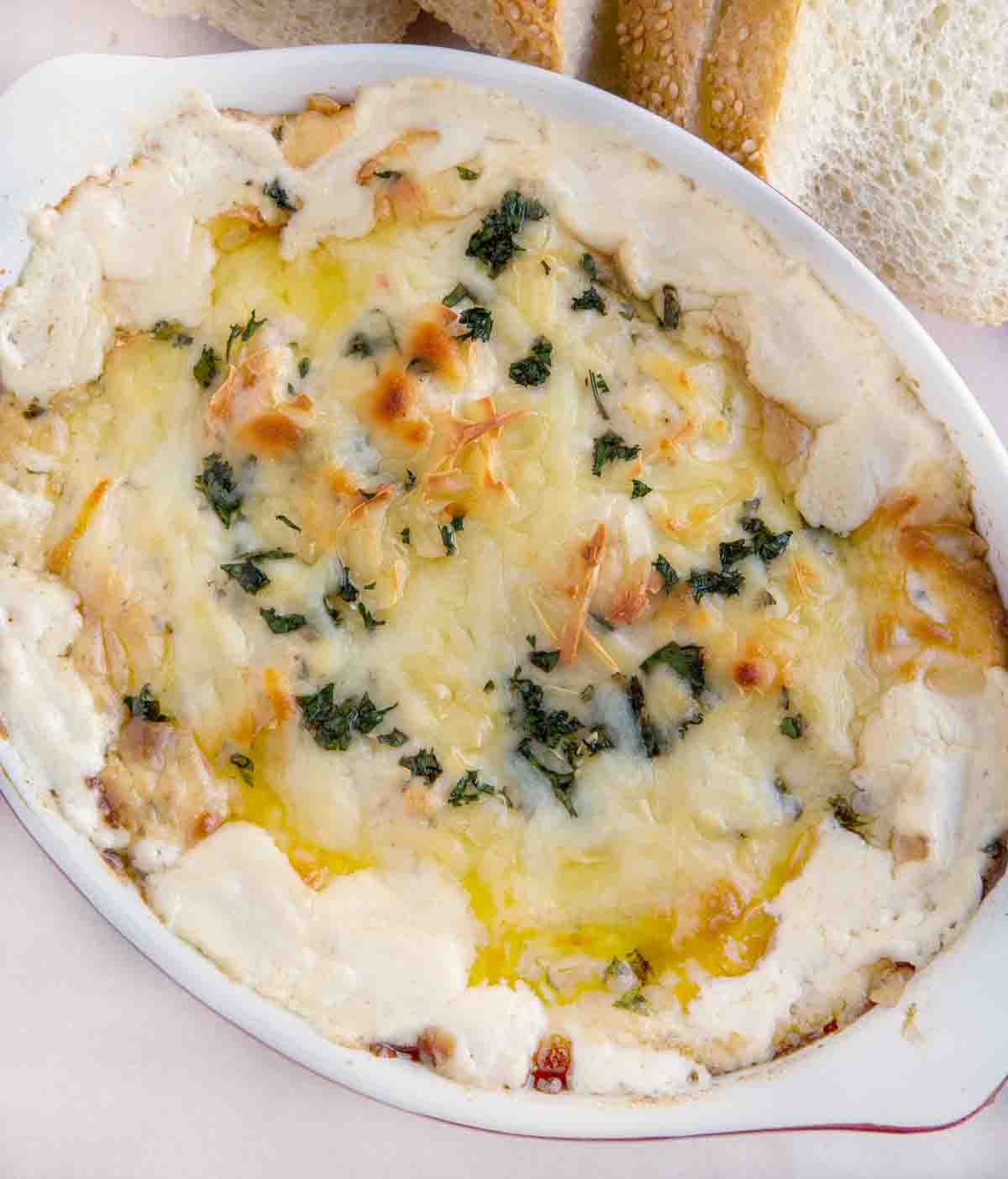 cheesy, bubbly shrimp scampi dip in a white casserole