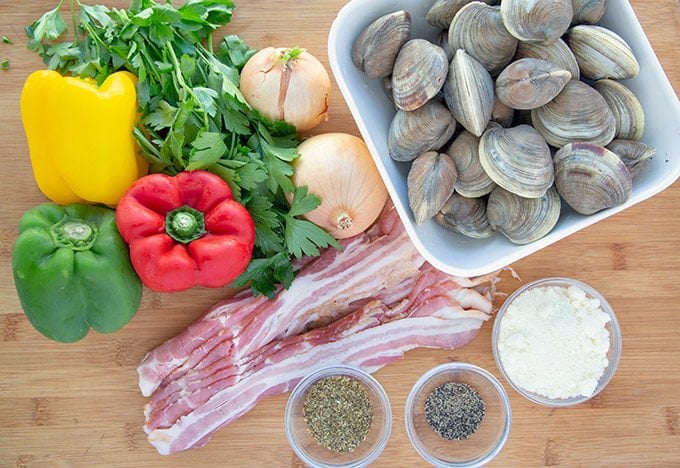 ingredients to make clams casino on a wooden cutting board