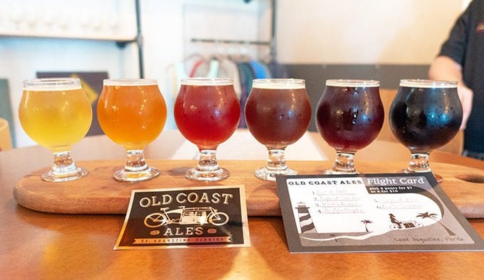 flight of six beers on a wooden tray 