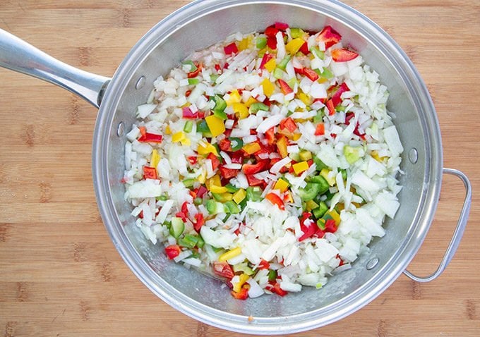 diced red, green and yellow peppers and diced onions in a large saute pan