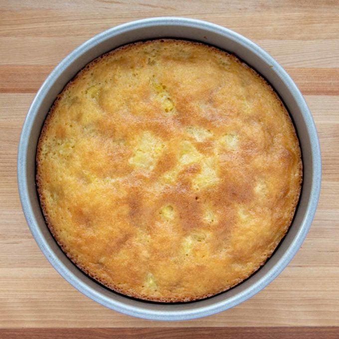 baked pineapple butter cake in cake pan on cutting board