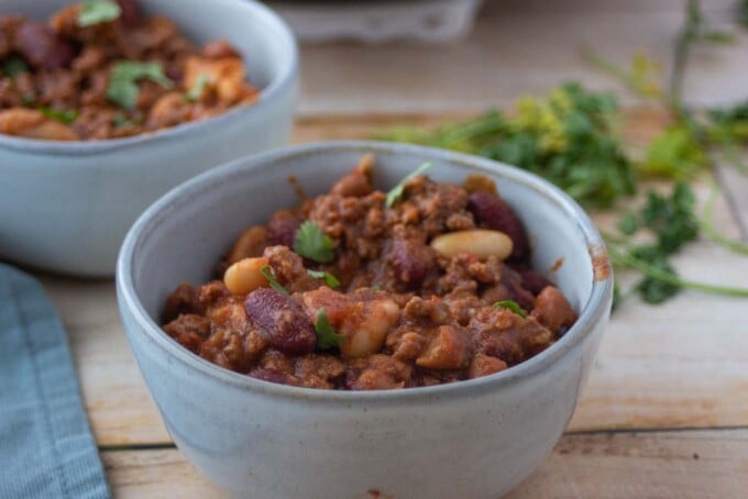 bowl of three bean chili with another bowl behind it