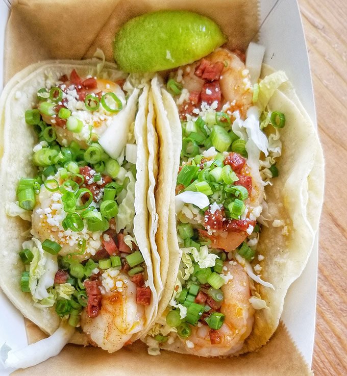 two Shrimp Tacos with a lime garnish