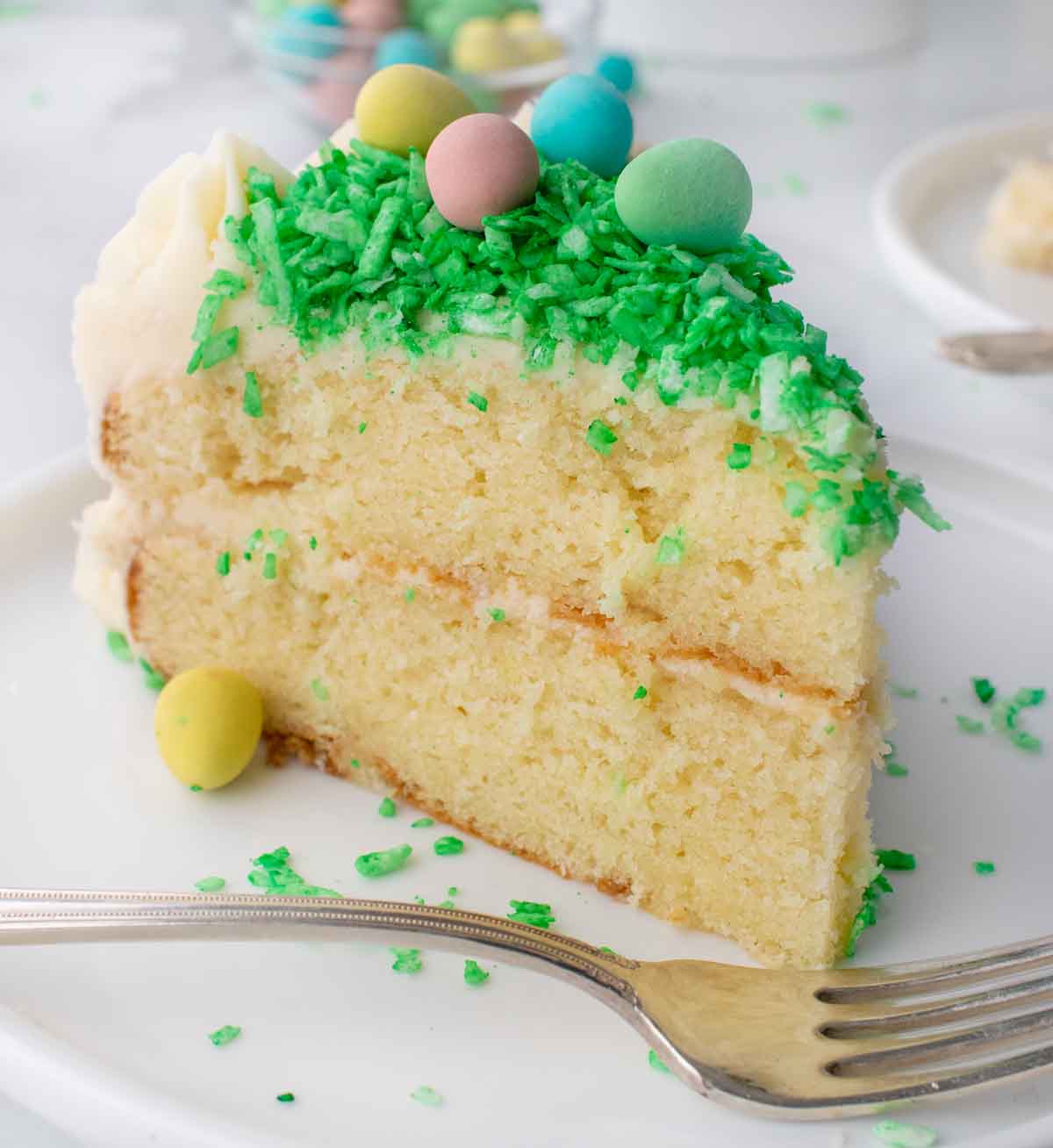 slice of coconut cake on a white plate with a fork