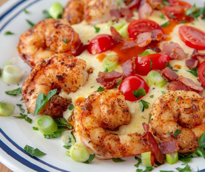 shrimp and grits close up on a white plate with blue trim