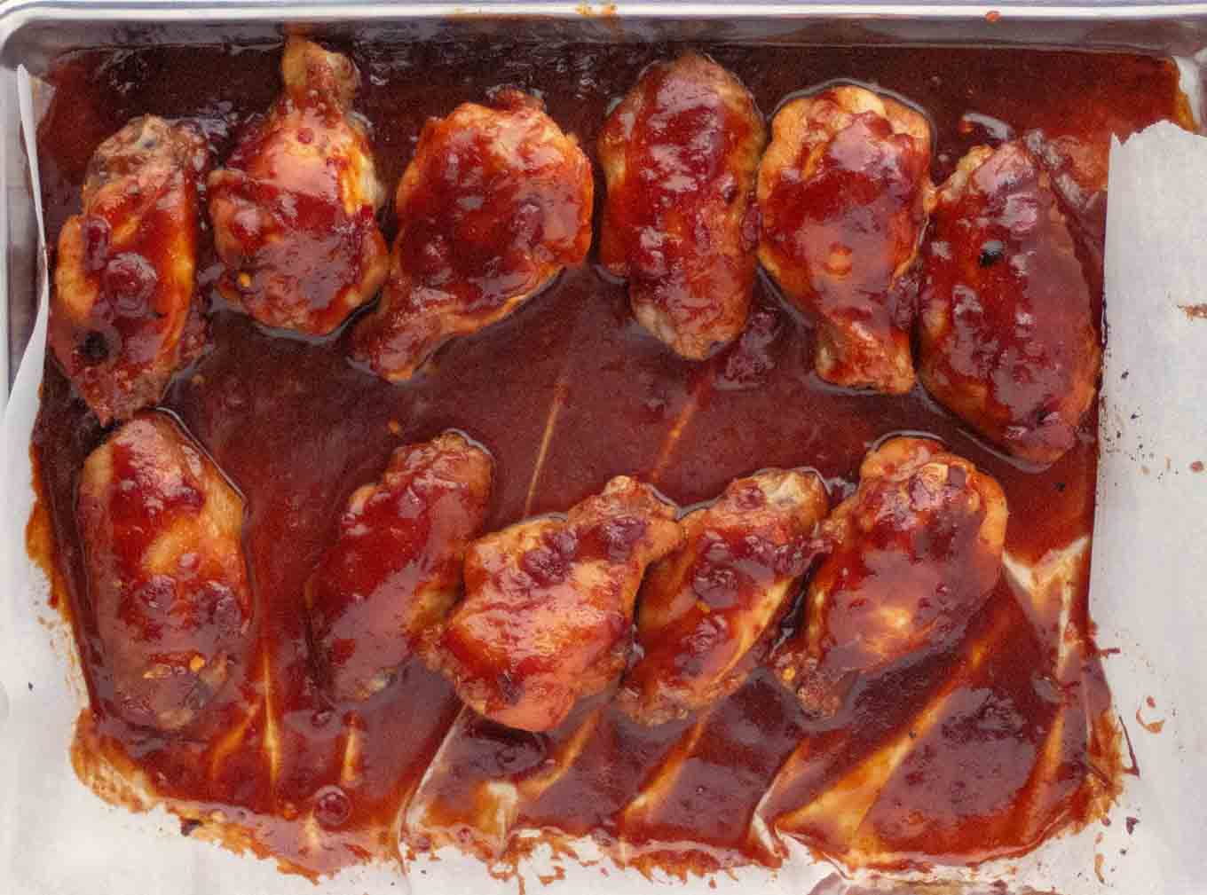 wings with additional marinade brushed on them on the baking sheet