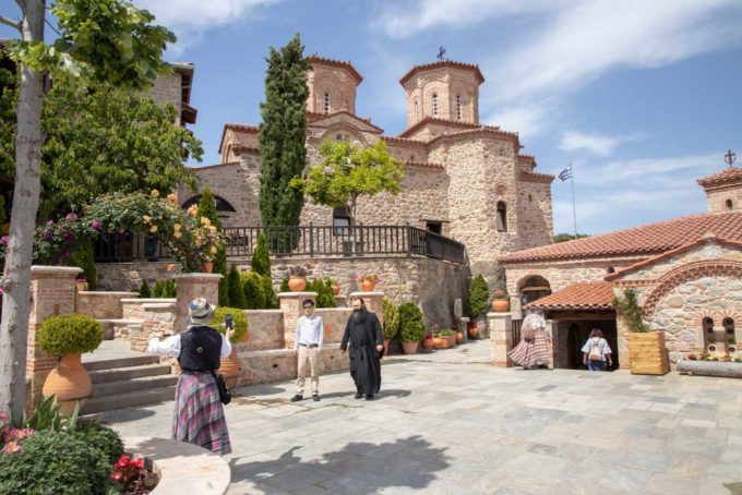 view of Monastery buidings in Meteora with Orthodox Monk walking
