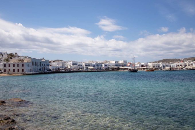 Town in Mykonos from the Beach showing crystal clear aqua water