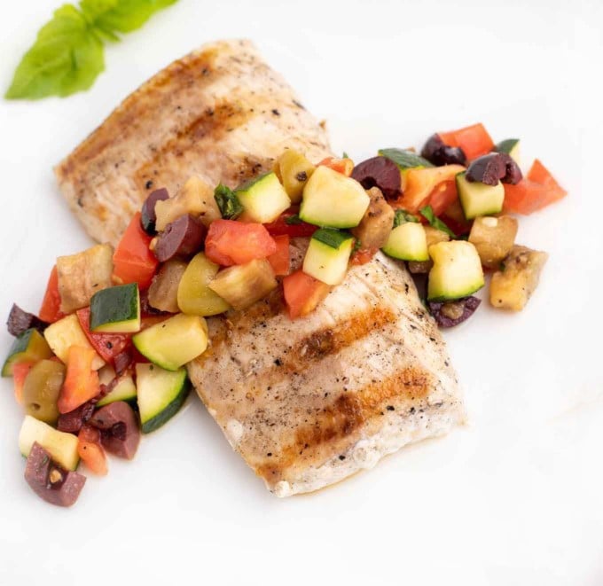 grilled mahi mahi with caponata on a white plate