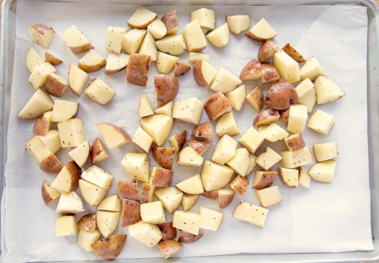 diced, oiled and seasoned red potatoes on a sheet pan