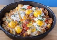 cast iron skillet breakfast with sunny side up eggs on top