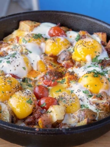 cast iron skillet breakfast with sunny side up eggs on top