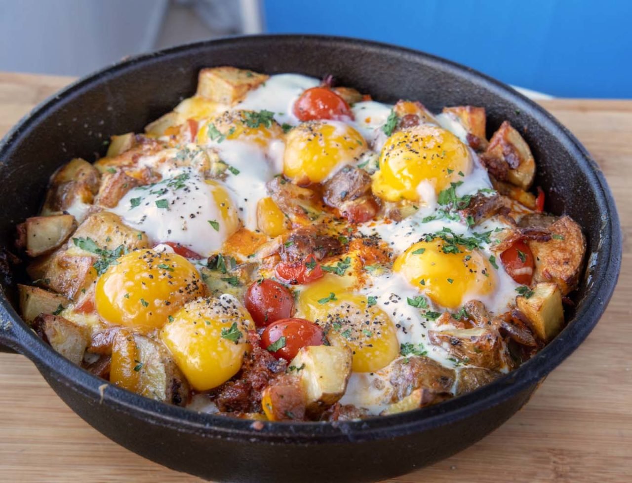 cast iron skillet breakfast with sunny side up eggs on top