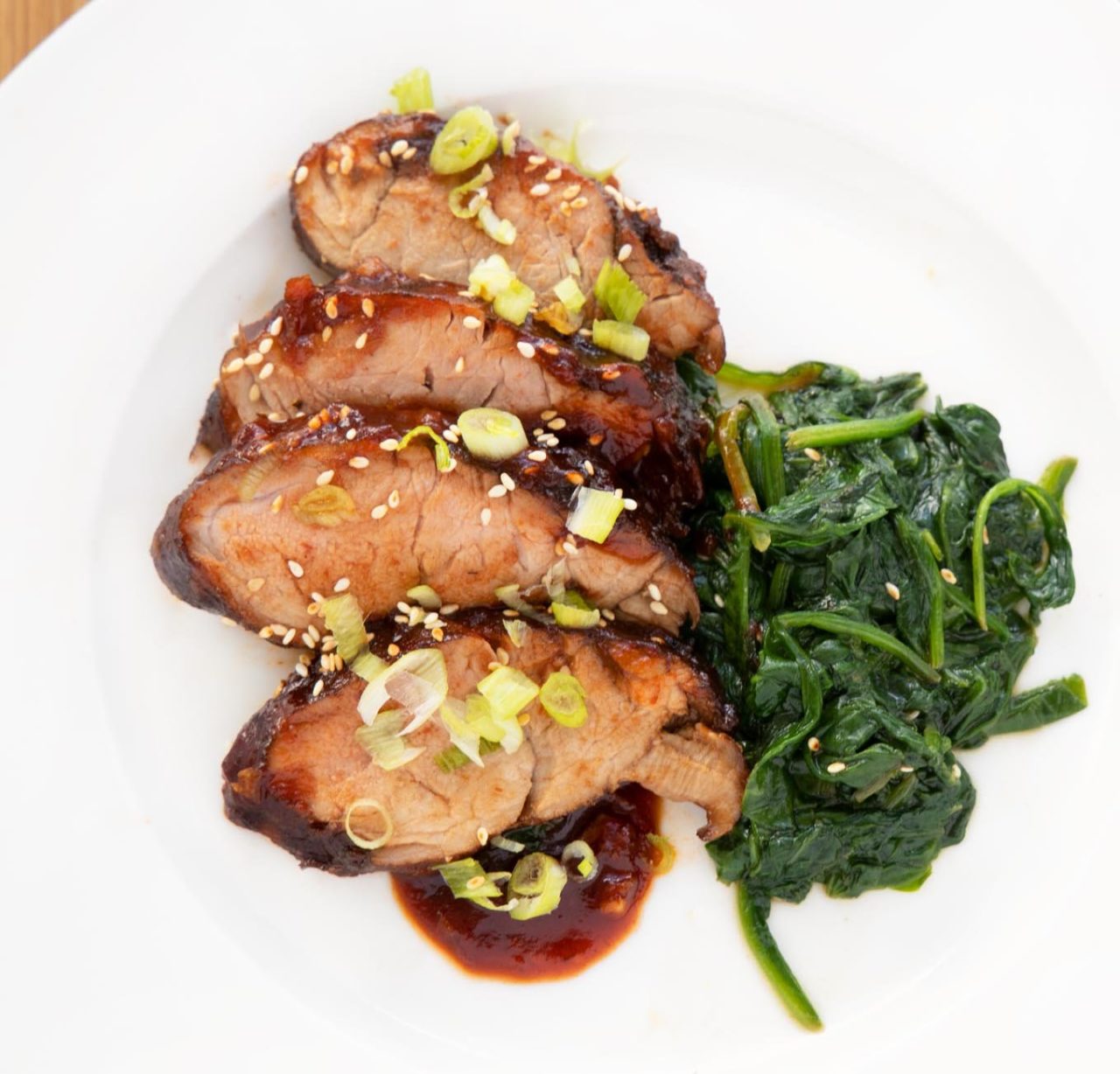 Korean Pork Barbecue and spinach on a white plate