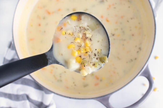 overhead view of corn chowder with a ladle of soup.