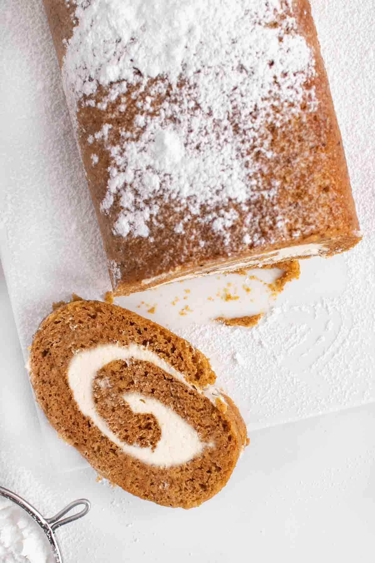 slice of pumpkin roll with the rest of the roll