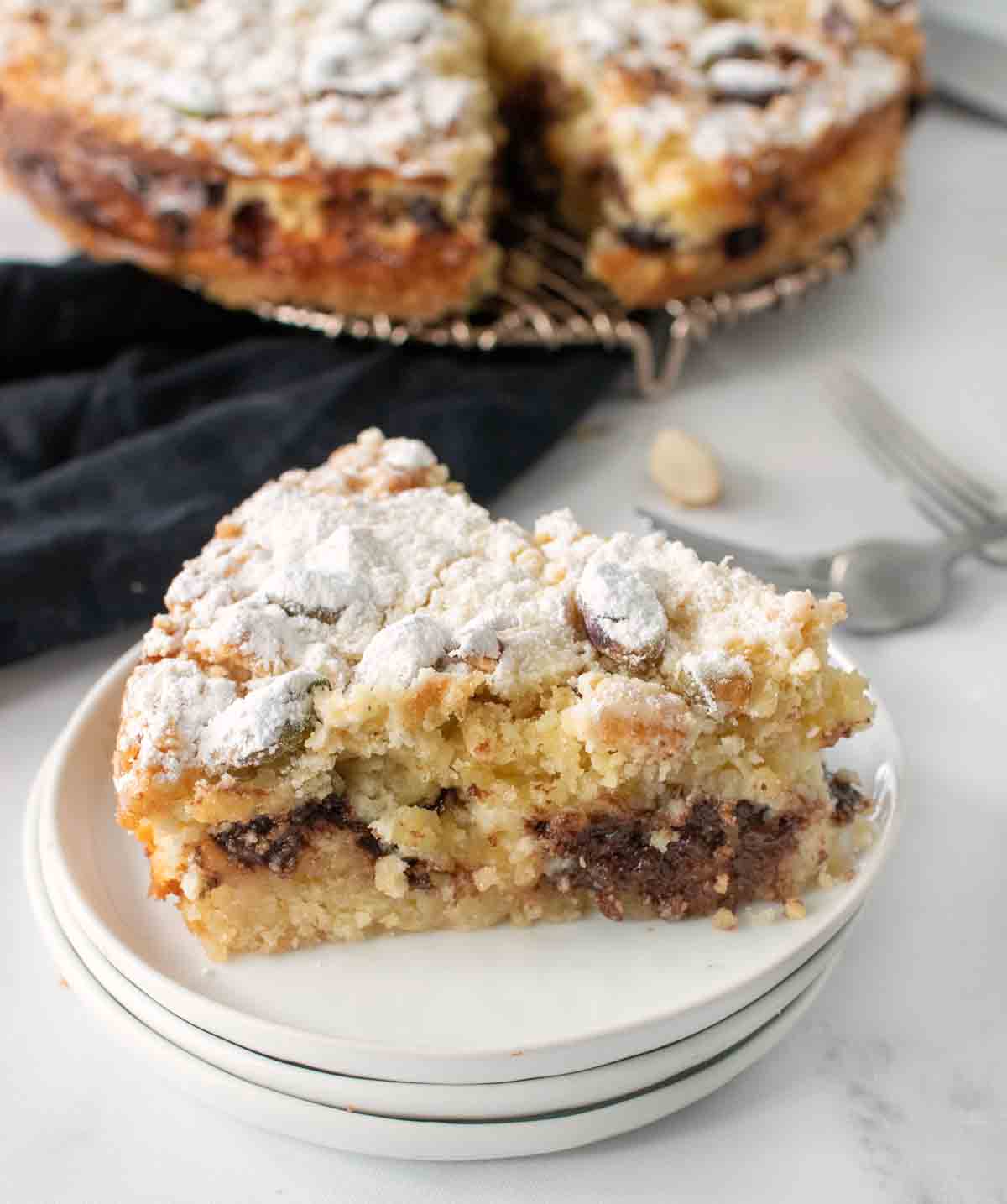 slice of ricotta chocolate chip cake on a stack of white plates