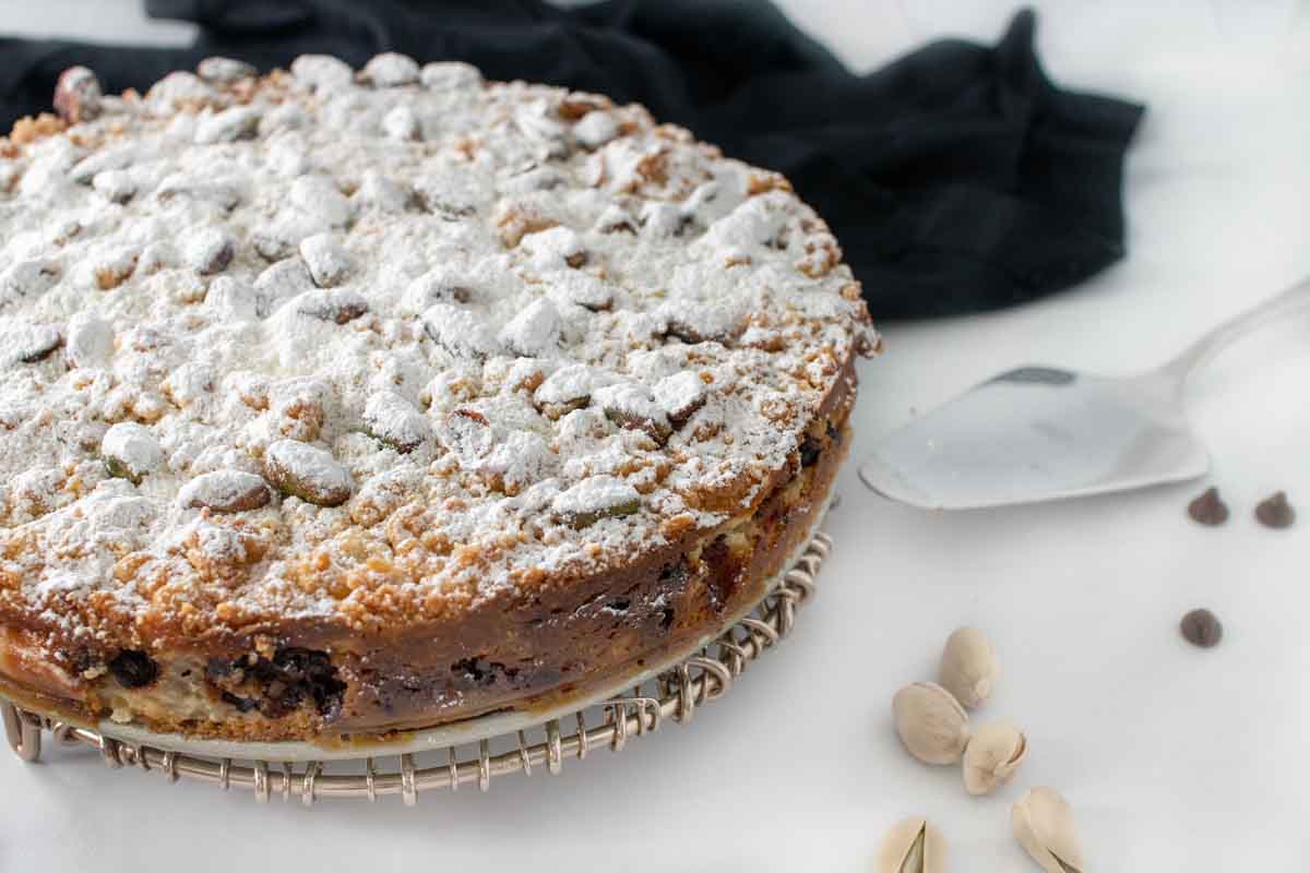 whole ricotta chocolate chip cake on a tray next to spatula