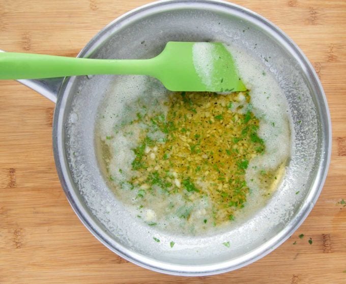 garlic butter in saute pan on a wooden cutting board