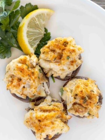 crab stuffed mushrooms on a white plate