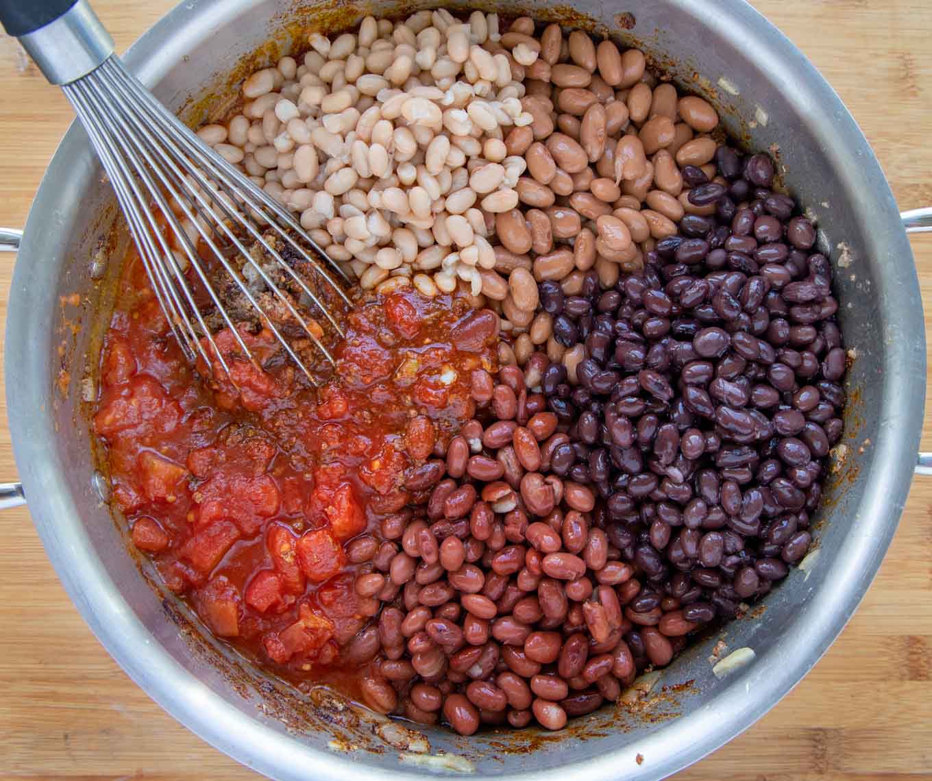 beans and tomatoes on top of the seasoned beef in a large suacepan