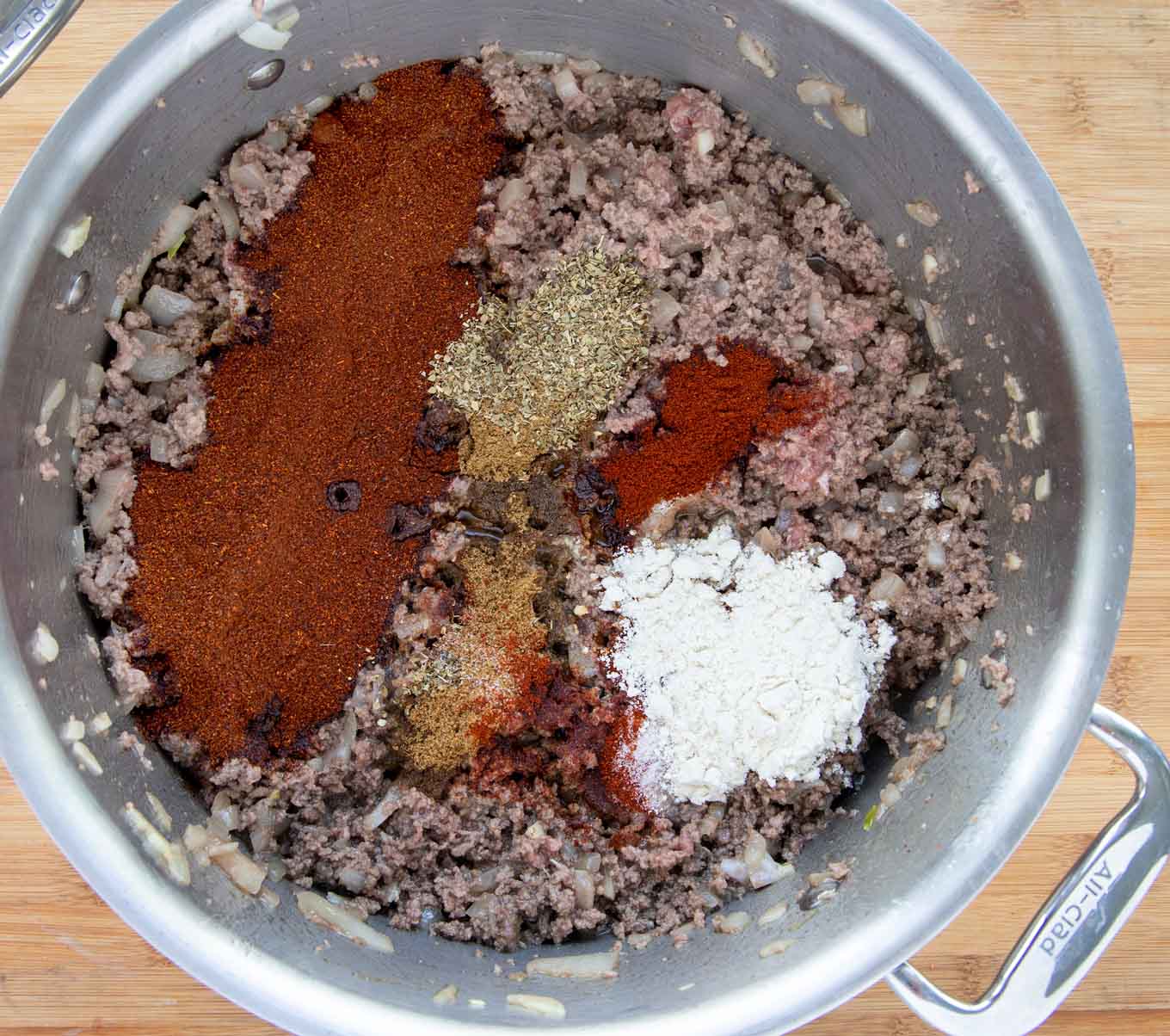 seasonings with cooked ground beef in a large sauce pan