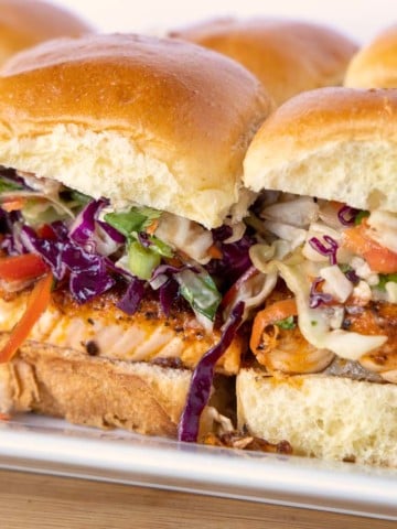 side view of blackened salmon sliders on a white tray