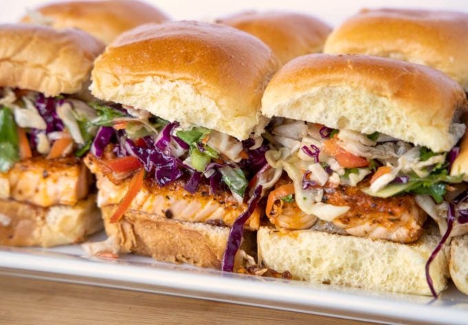 side view of blackened salmon sliders on a white tray