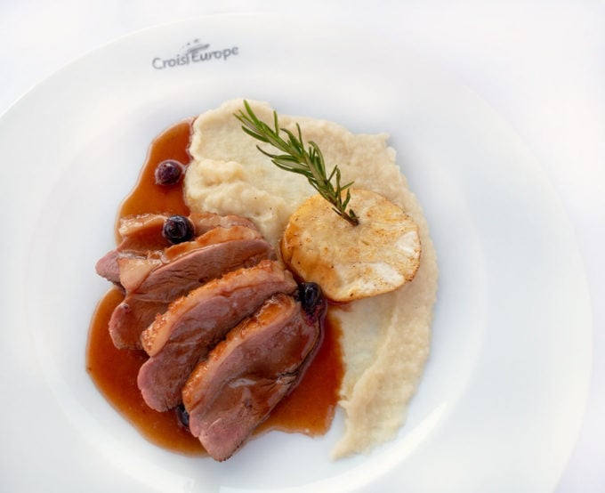 slices of duck breast and potatoes on a white plate