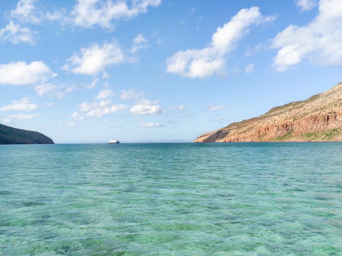 crystal clear aqua waters of the sea of cortez with mountains in the background