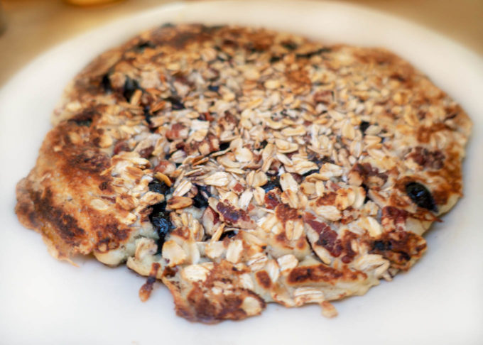 one oatmeal pancake with blueberries and pecans