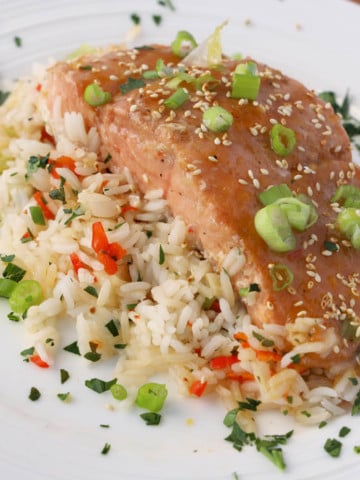 Mango Bourbon Salmon on a bed of seasoned rice on a white plate