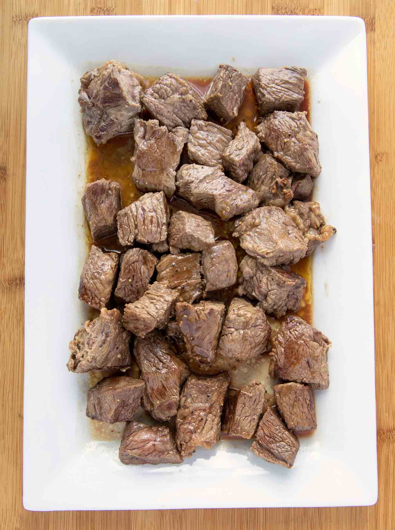 pan seared beef cubes on an oblong white platter