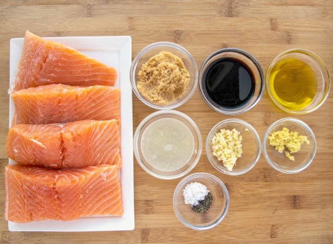 salmon filets and ingredients for marinade on a wooden cutting board